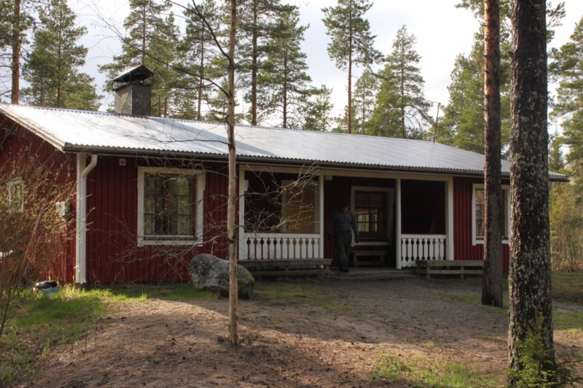 Metsola — perinteinen hirsimaja lumisessa havumetsässä